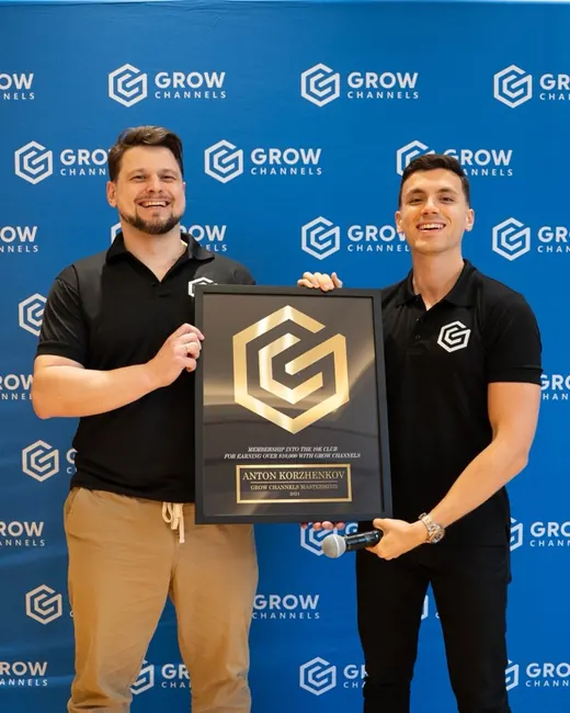 Anton Korzhenkov holding their 10K Club plaque