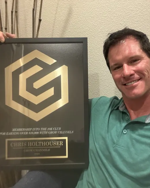 Chris Holthouser holding their 10K Club plaque