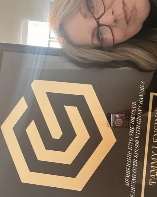 Tammy Lensing holding their 10K Club plaque