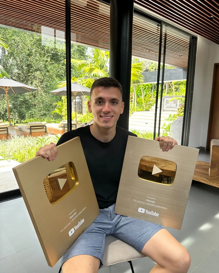 Razvan Paraschiv holding two YouTube Gold Play Button awards